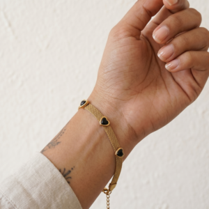 Just Jewel Anti-Tarnish and Waterproof Gold Mesh Bracelet with Black Heart Charms on model's hand.