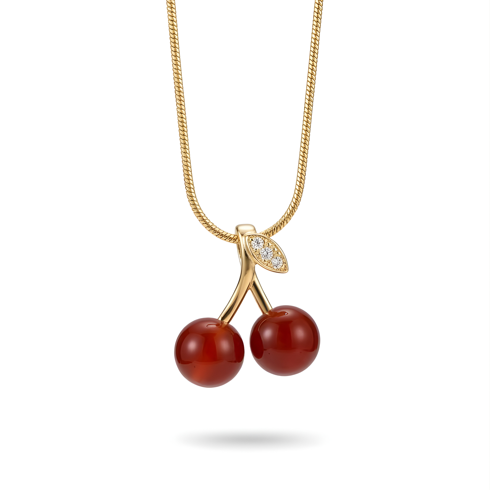 Close-up of a glossy Red Cherry Pendant with Crystal Leaf on a Gold Snake Chain